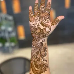 This bridal design features the name 'Mohit' written gracefully along the side of the hand, blending seamlessly with the floral patterns.