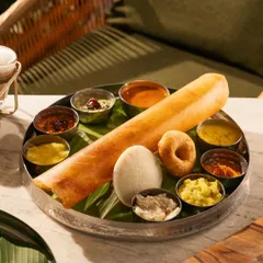 A complete South Indian breakfast platter with dosa, idli, vada, and various chutneys. This is a feast for the eyes.