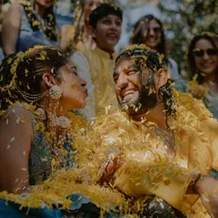 A playful kiss amidst a shower of yellow petals. The Haldi ceremony is full of fun and candid moments like this, and we make sure to capture all the joyful interactions.