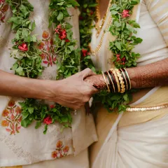 A close-up showing the beautiful details of actor Rajesh Madhavan's wedding attire. The groom's printed shirt and kasavu mundu are a perfect blend of modern and traditional styles.