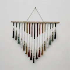 This colorful V-shaped wall hanging is a piece of art for your home. I carefully select each color and knot every tassel by hand to create a vibrant design that brings joy to any room. It's a perfect statement piece for a living room or entryway.