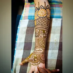 A close-up of the forearm, highlighting the floral band and jaali pattern in this personalized design.