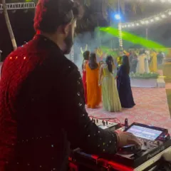 From my perspective behind the decks at a vibrant outdoor wedding. I love watching the dance floor fill up as I mix the perfect tracks for the celebration.