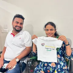 A happy couple with the custom-painted baby t-shirt they made during their baby shower celebration.