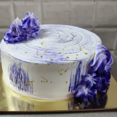 A white cake with a modern, abstract purple watercolor effect and gold flecks. A simple design that makes a big impact.