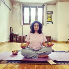 A student holding two small Tibetan bowls during a meditation session. Connecting with the bowls directly can be a powerful and personal experience.