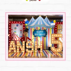 A classic circus-themed birthday stage with a big top backdrop, marquee letters, and a ringmaster prop for the perfect photo op.