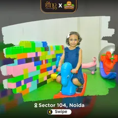 A young girl enjoys a ride on a colorful rocker next to a wall of giant building blocks. Our toddler area is filled with safe, age-appropriate toys for imaginative play.