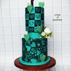 This two-tier wedding cake shows how artistic you can get without fondant. I used a detailed stenciling technique with black cocoa on teal buttercream to create the intricate heart patterns, giving it a bold, modern, and unforgettable look.