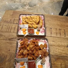 A platter of classic crowd-pleasers. We serve crispy Veg Spring Rolls and savory Gold Coin appetizers, both fried to golden perfection and accompanied by a sweet and spicy dipping sauce.