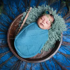 An overhead view of another Little Krishna setup, this time with a vibrant blue wrap and a full fan of peacock feathers, showcasing the versatility within our themes.