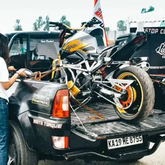 A stunt bike is carefully unloaded from a truck. The logistics and preparation behind the scenes are immense, ensuring every part of the show runs smoothly and safely.