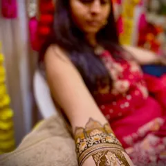 A close-up shot of the Ganesha portrait on the arm, showing the fine lines and shading that bring the deity to life. This is a popular choice for brides who want a divine element in their mehendi.