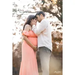 A tender moment between expecting parents, framed by the soft light of the outdoors. This image focuses on their closeness and the shared anticipation of welcoming their third family member.
