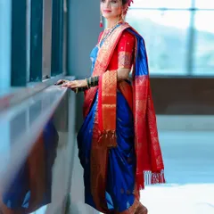 A full-length portrait of a stunning Maharashtrian bride in a vibrant blue and red Nauvari saree. I make sure to capture the elegance of the complete bridal look, including the traditional drape and posture.