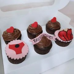 A box of naughty-themed cupcakes with "Breast Wishes" for the bride-to-be.