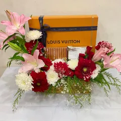 A simple yet elegant floral gift hamper perfect for any corporate occasion. This version features a Louis Vuitton box surrounded by soft pink lilies and red and white chrysanthemums.