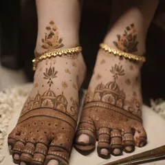 Bridal mehendi isn't complete without adorning the feet. This design features delicate lotus flowers and architectural domes, creating an elegant look that complements the anklets perfectly.