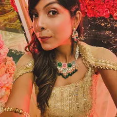A close-up of a wedding season look. I styled this gold lehenga with a statement necklace that has pops of pink and green, adding a modern touch. I help clients select jewellery and makeup that perfectly complements their outfits.