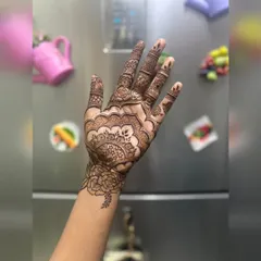 A detailed mandala design on the palm. This style is centered and symmetrical, creating a very balanced and traditional look for festive events.