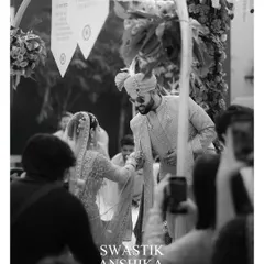 A candid black and white moment from the ceremony. This shot, taken from the perspective of a guest, captures the couple's connection and the reality of being surrounded by loved ones.