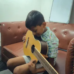 The pure joy of a child connecting with a guitar for the first time. Our lessons are designed to be fun and inspiring.