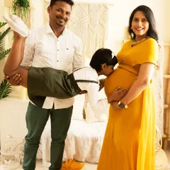 Maternity sessions can be fun and playful. Here, the older brother to be gives a kiss to the baby bump, held up by his father, creating a lighthearted and memorable family photograph.
