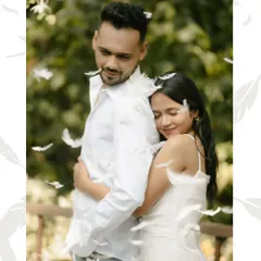 A soft and dreamy portrait of Nirav and Alpi surrounded by falling feathers. This intimate embrace captures a quiet, tender moment that feels both magical and deeply romantic.