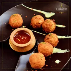 These golden-fried cheese balls are a crowd-favorite appetizer. Served with a tangy dipping sauce, they are crispy on the outside and filled with warm, melted cheese.