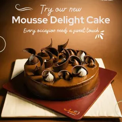 Our Mousse Delight Cake is an airy, creamy, and intensely chocolatey creation. Decorated with elegant chocolate swirls, it's a light yet decadent dessert that melts in your mouth.