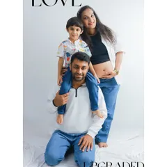 Love upgraded! Welcoming a new baby is a family affair. This fun and casual studio portrait captures the excitement of a growing family, with big brother perched happily on his dad's shoulders.