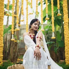 A stunning bride-to-be at her Haldi ceremony. The 'Yellow Land' theme, with cascading marigold garlands and lush greenery, creates a perfect setting for this joyous ritual.