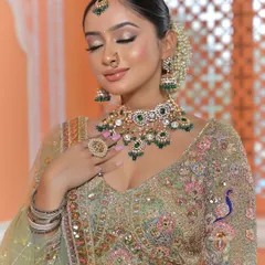A perfect example of how jewellery can elevate a look. This stunning Polki and green gemstone choker set contrasts beautifully with the pastel green lehenga. This is a popular choice for brides who want a traditional feel with a touch of modern color.