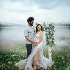 A romantic couple's portrait set against a misty lakeside. The floral arch adds a touch of magic, perfectly framing their loving gaze during this outdoor maternity session.
