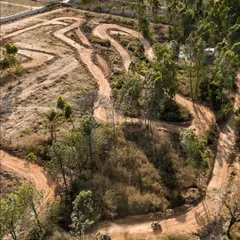 An aerial view of our winding dirt kart track. It's carved right into the natural landscape, making for an authentic off-road racing experience.