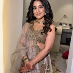 A full view of this stunning cocktail glam look. The soft waves in her hair add texture and movement, perfectly balancing the dramatic eye makeup for a cohesive and glamorous appearance.