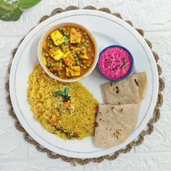 A beautifully plated meal featuring our popular Mutter Paneer, vibrant Beetroot Raita, fragrant Veg Pulao, and soft rotis. This is a perfect example of a balanced and delicious lunch.