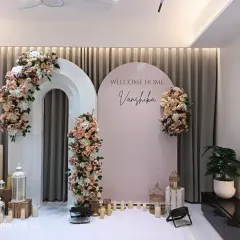 A soft and elegant welcome decoration for a bride. I used pastel pink arched panels with the name "Vanshika," decorated with beautiful blush and white floral arrangements.