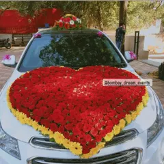 A grand floral statement on wheels. This car is decorated with a giant heart made of red and yellow flowers on the hood, perfect for weddings or a very special romantic gesture.