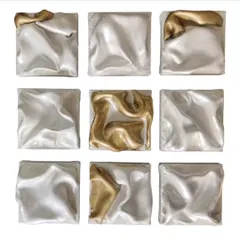 'The Dancing Squad' is a nine-panel abstract sculpture. The fluid, raised forms on each panel suggest bodies in motion, with the gold accents highlighting the lead dancers in this metallic ballet.