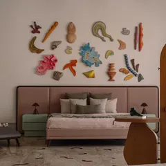 The showstopper of this bedroom is the 'Love is a Wave' wall installation, a collaboration with a talented artist. The collection of handcrafted ceramic pieces evokes the serenity of the ocean, turning the wall behind the bed into a captivating art piece.