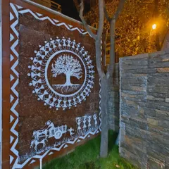 This is my Tree of Life Warli mural, painted on an exterior compound wall and seen here at night. The central tree symbolizes life and connection, surrounded by figures in a celebratory dance, creating a powerful piece of traditional Indian wall art.