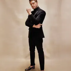 Texture tells a story. In this dark-hued corduroy suit, paired with a classic turtleneck, the narrative is one of depth, detail, and an undeniable presence, perfect for sophisticated evening events.