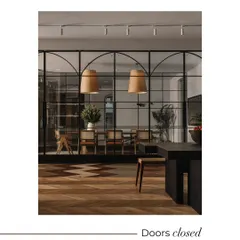The arched, black-framed glass partitions are a key design feature, shown here with the doors closed. This creates an elegant, enclosed conference room, offering privacy without visually disconnecting from the larger showroom.