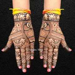 This full-hand design features beautiful peacock hearts and lotus flowers, tied with a traditional 'kalava' thread for an auspicious touch.