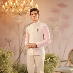 This look for Louis Philippe's wedding collection features a subtle, off-white jacquard bandi jacket over a pastel pink shirt. The styling is soft and elegant, presenting a modern and refined option for daytime wedding festivities.