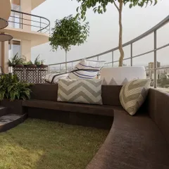 A built-in curved bench with a central grass patch creates a unique and cozy seating area, blurring the line between architecture and landscape.