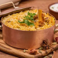 A beautiful shot of our authentic lamb biryani, slow-cooked with fragrant spices and served in a traditional copper pot. This dish is a highlight of our modern Indian menu, which evolves through tradition and experimentation.