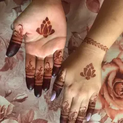 A very minimalist and modern design featuring a single lotus motif on each palm and the back of the hand. The fingers have simple, elegant details to complete the look.
