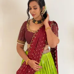 This is a beautiful traditional half saree, or Langa Voni, available for rent. The combination of a vibrant lime green skirt and a rich maroon blouse and dupatta is a classic South Indian choice.